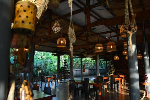KOFAN Ecohotel في بويرتو أسيس: غرفة طعام مع طاولات وكراسي وأضواء