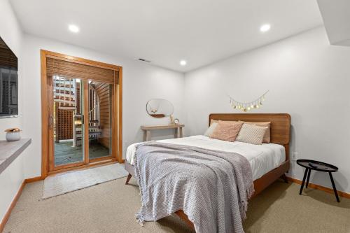 a bedroom with a bed and a sliding glass door at Relaxing Catskill Escape- Mountain Views - Hot Tub - Fire Pit - Heated Pool in Catskill