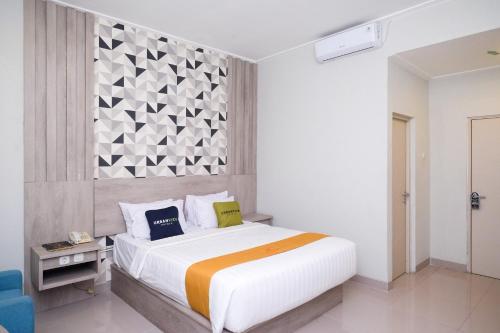 Un dormitorio con una cama grande y una pared en Urbanview Hotel Dedy Jaya Brebes, en Brebes
