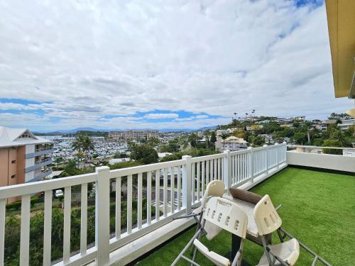 a balcony with a chair and a view of a city at Auberge du MOCAMBO in Noumea