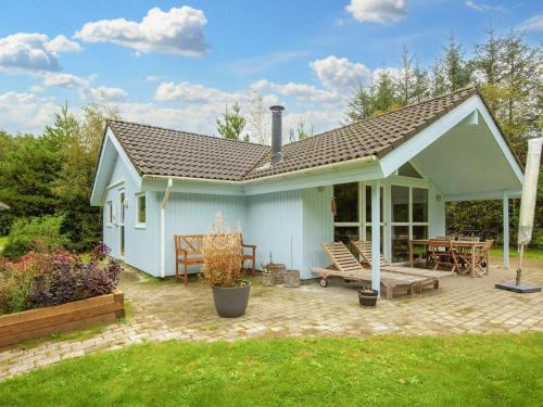 a small blue house with a patio and a table at 6 person holiday home in Oksbøl-By Traum in Oksbøl