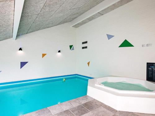 a swimming pool in a room with a tub at 12 person holiday home in Bl vand in Blåvand
