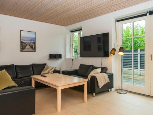 a living room with a couch and a table at 12 person holiday home in Ulfborg in Øby