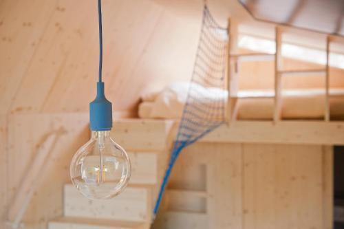 una bombilla colgando del techo de una habitación en Green Tiny Village Harz - Tiny House Pioneer 7, en Osterode