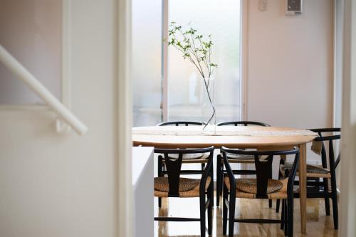 a dining room table with chairs and a vase with flowers at 和光荘 Harmonious Light West in Hakone