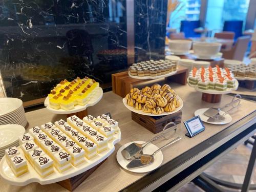 a display case filled with different types of cakes and pastries at Wyndham Garden Hanoi in Hanoi