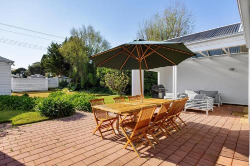 a table and chairs with an umbrella on a patio at Beachside Retreat Blairgowrie in Blairgowrie