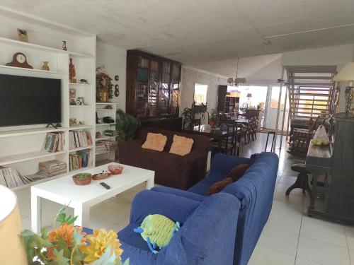 a living room with two blue couches and a tv at Hostal Renca, Casa Hotel in Santiago