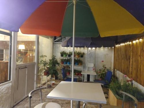 uma mesa com um guarda-chuva colorido num quarto em Hostal Renca, Casa Hotel em Santiago