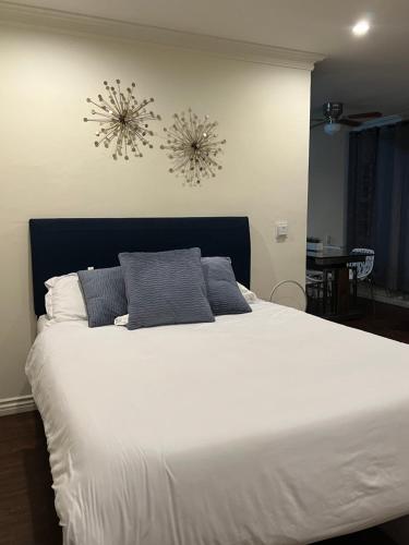 a bedroom with a large white bed with blue pillows at Centrally located UCLA Condo in Los Angeles