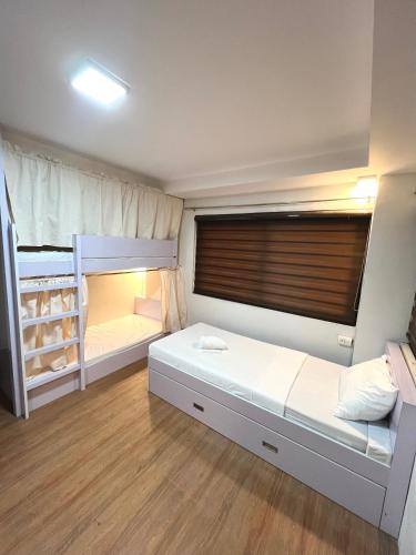a bedroom with two bunk beds and a window at Staycation Hotel in San Jose