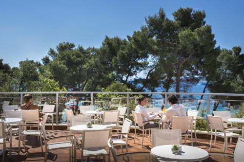 a group of people sitting at tables on a patio at Aminess Vival Grand Azur Hotel in Orebić