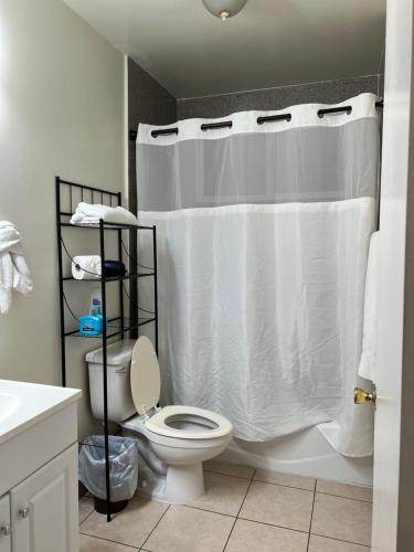 a bathroom with a white shower curtain and a toilet at Centrally located UCLA Condo in Los Angeles