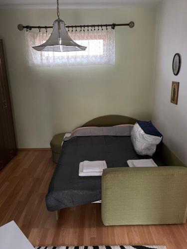 a bedroom with a bed and a couch and a light at Kuća na selu “ANNA” in Feketić