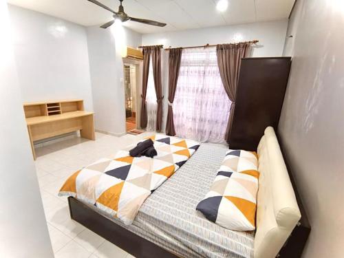 um quarto com uma cama com um cobertor xadrez em Welcome Home em Sungai Petani