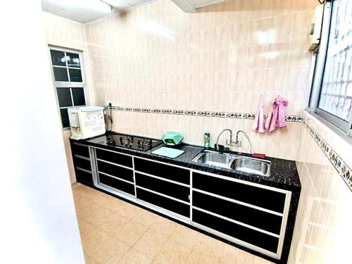 uma cozinha com um lavatório e uma bancada em Welcome Home em Sungai Petani
