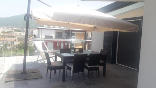 een eettafel en stoelen onder een parasol op een balkon bij Appartamento B&B La Meta in Fisciano