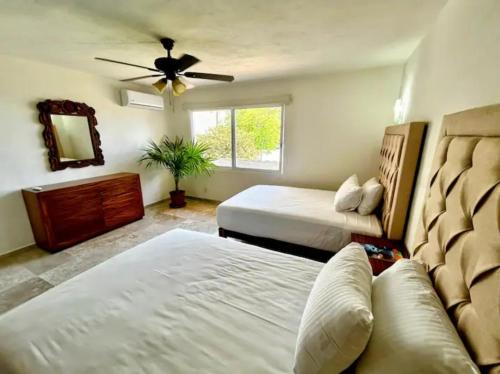 a bedroom with two beds and a ceiling fan at Villa Marina in Puerto Vallarta