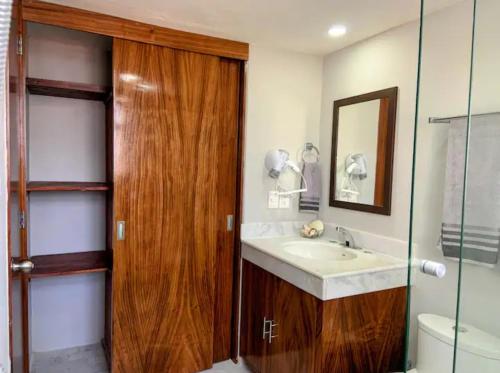 a bathroom with a sink and a wooden door at Villa Marina in Puerto Vallarta
