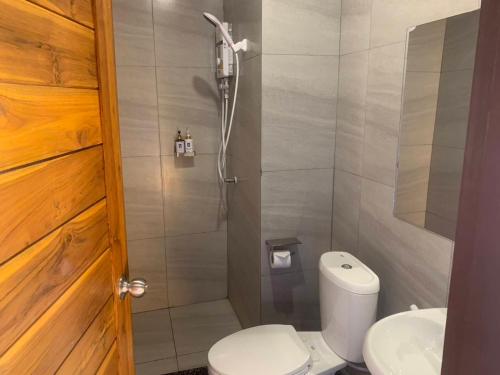a bathroom with a shower with a toilet and a sink at The C Hotel in Amnat Charoen