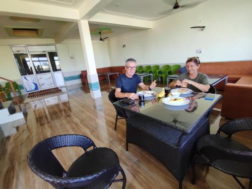 dos hombres sentados en una mesa en un restaurante en Sunrise Homestay en Agra