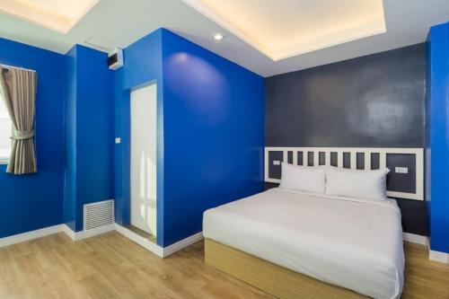 a bedroom with blue walls and a bed at Metro Link Ratchada Hotel in Bangkok
