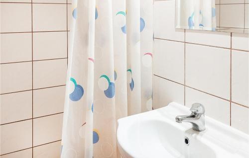 a bathroom with a sink and a shower curtain at 3 Bedroom Beautiful Apartment In Wiselka in Wisełka