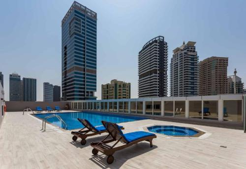 Cozy 2BR Delux Apartment in Dubai Marina في دبي: مسبح فوق مبنى فيه مباني