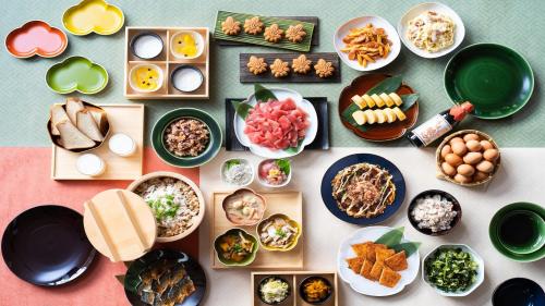 une table avec des assiettes et des bols de nourriture dans l'établissement Vessel Inn Fukuyama Eki Kitaguchi, à Fukuyama