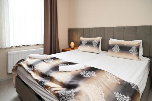 a bedroom with a large bed with white sheets and pillows at Kispet Deluxe Hotels&Suites in Oberhausen