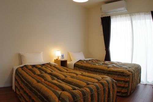 Postel nebo postele na pokoji v ubytování 笠岡　潮待ちHOTEL