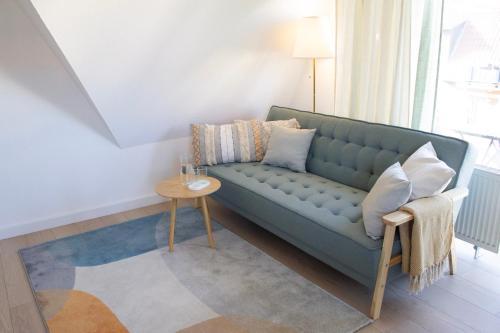ein Wohnzimmer mit einem blauen Sofa und einem Tisch in der Unterkunft NOVA - See APT 22 I Phantasialand I Cologne I Bonn in Erftstadt