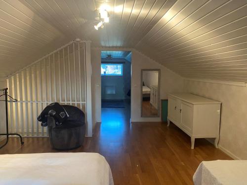 an attic room with a bed and a dresser in it at Villa Gasabäck in Söråker