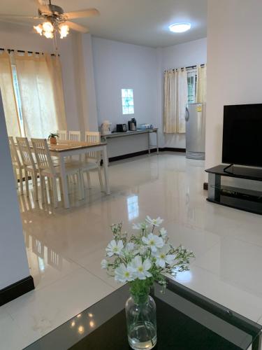 a living room with a vase of flowers on a table at Baan Khun House in Nakhon Ratchasima