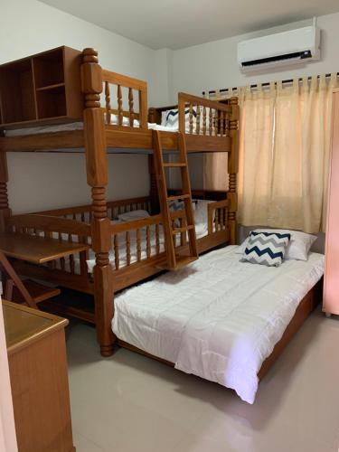 a bedroom with two bunk beds in a room at Baan Khun House in Nakhon Ratchasima
