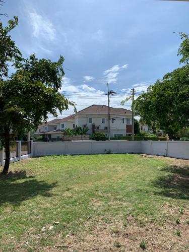 a yard with a fence in front of a house at Baan Khun House in Nakhon Ratchasima