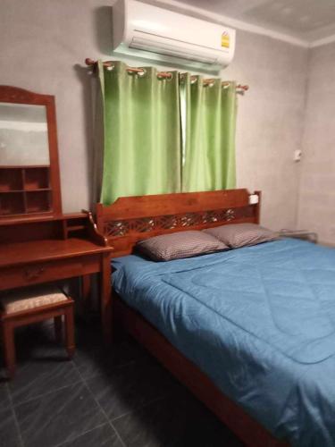 um quarto com uma cama, um espelho e um piano em โฮมสเตย์ แม่ปราณี 