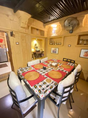 Hamari Haveli في جيلسامر: غرفة طعام مع طاولة مع كراسي بيضاء