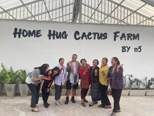 a group of people standing in front of a sign at โฮมสเตย์ แม่ปราณี 
