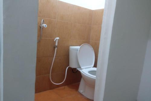 La salle de bains est pourvue d'une douche et de toilettes. dans l'établissement OYO 93100 Harapan Homestay Syariah, à Parit