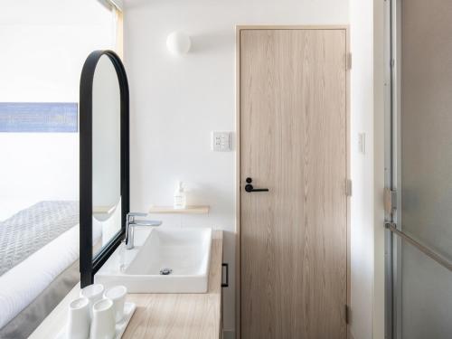 a bathroom with a sink and a mirror at Vessel Hotel Fukuyama in Fukuyama