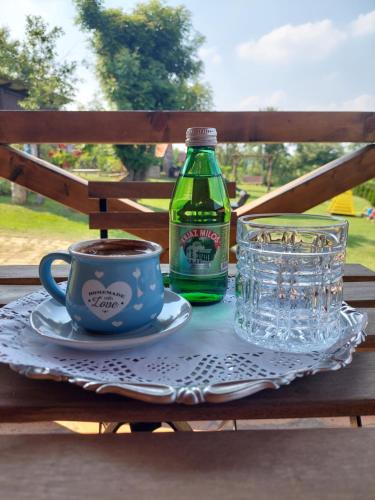 a table with a bottle of soda and a cup of coffee at Palanačka Avlija 2 in Ripanj