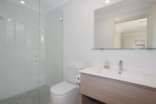a bathroom with a toilet and a sink and a mirror at All Decked Out in Hawks Nest