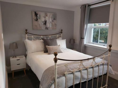 1 dormitorio con cama blanca y ventana en #4 The Quirky Quarters, en Portsmouth