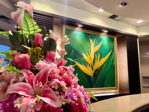 a painting of flowers in front of a table at โรงแรม ซิตี้พาร์ค โคราช City Park Hotel in Nakhon Ratchasima