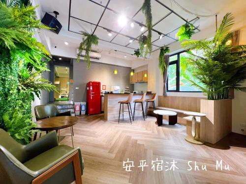 a room with plants and tables and a red refrigerator at Anping Su Mu in Anping