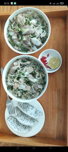 three bowls of food on a wooden table at Hang Mua Eco Garden in Xuân Sơn