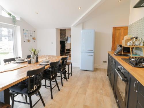 a kitchen with a long wooden table and chairs at Cooper's Rest Gorffwysfa Coopers in Dolwyddelan