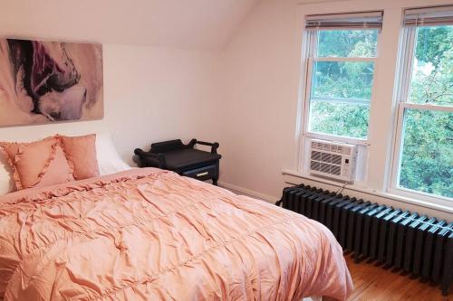 a bedroom with a bed and two windows at Pinkston Gardens in Saint Paul