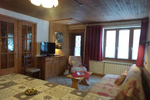 ein Schlafzimmer mit einem Bett und einem TV in einem Zimmer in der Unterkunft Chez Bernard & Chantal in Peisey-Nancroix